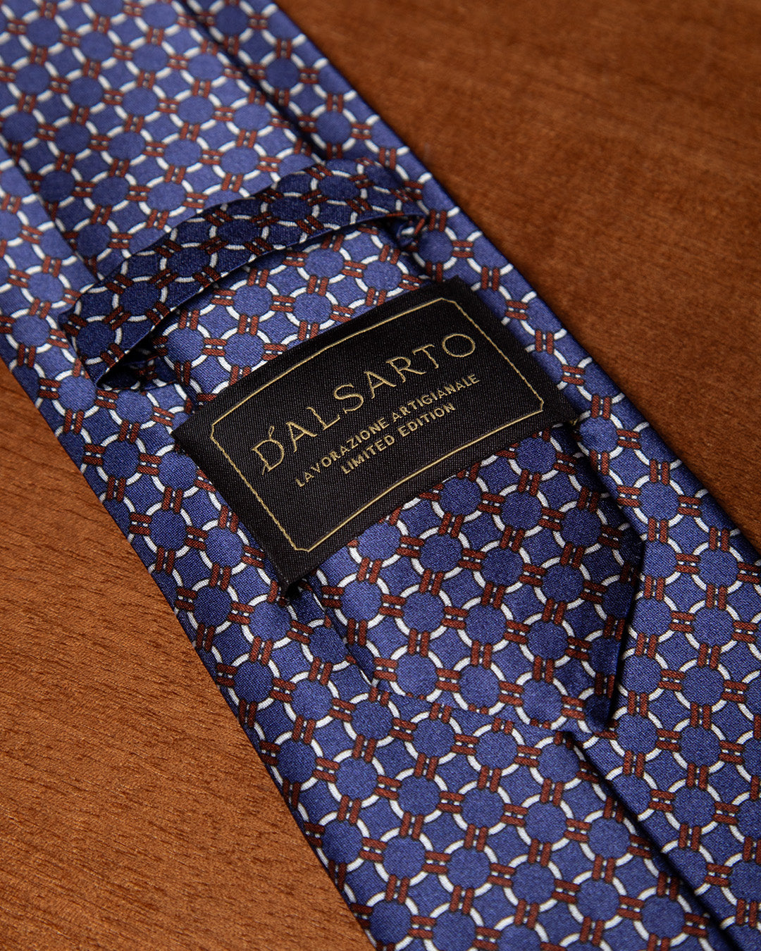 Cravatta Blu con Anelli Bianchi e Dettagli Bronzo