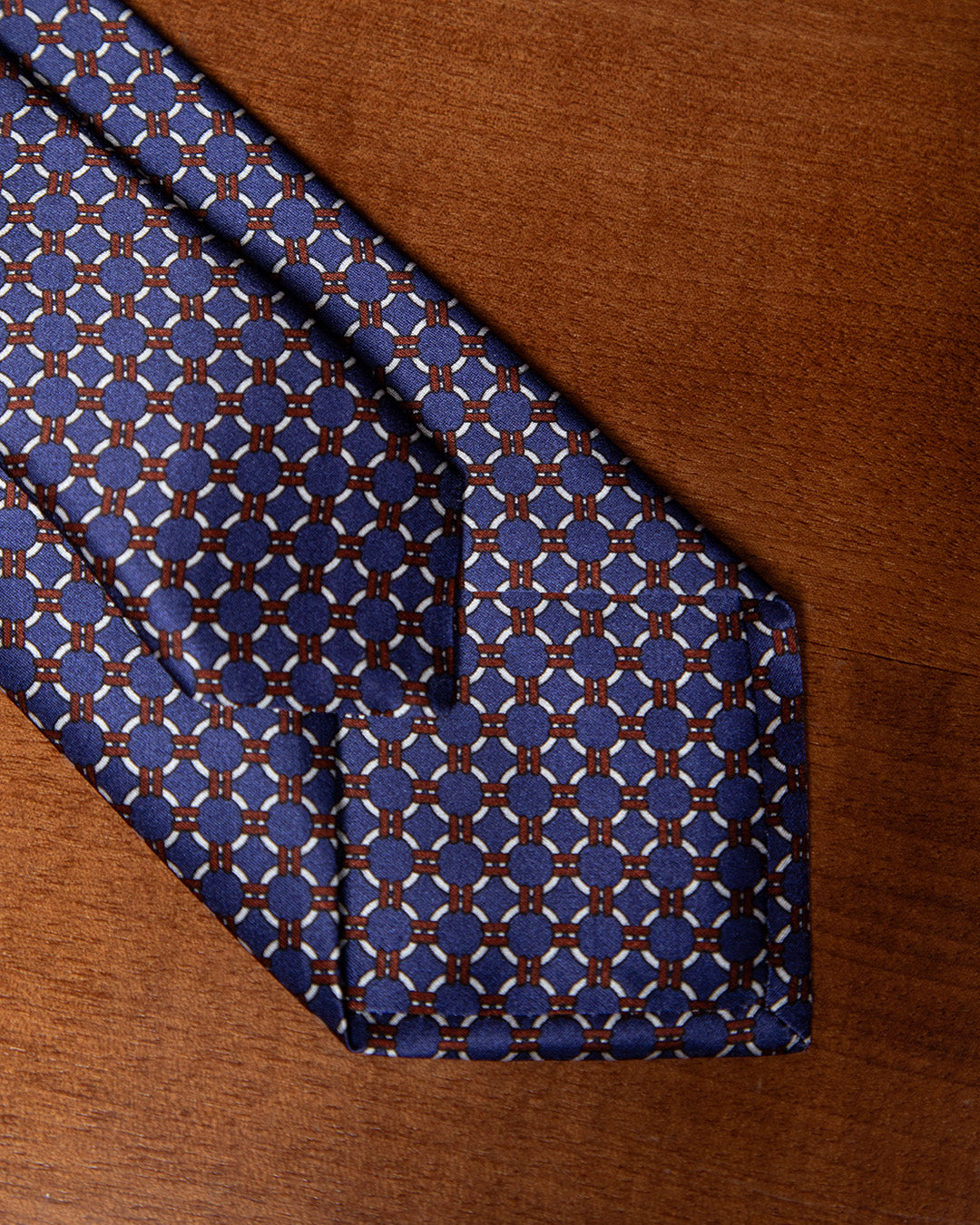 Cravatta Blu con Anelli Bianchi e Dettagli Bronzo