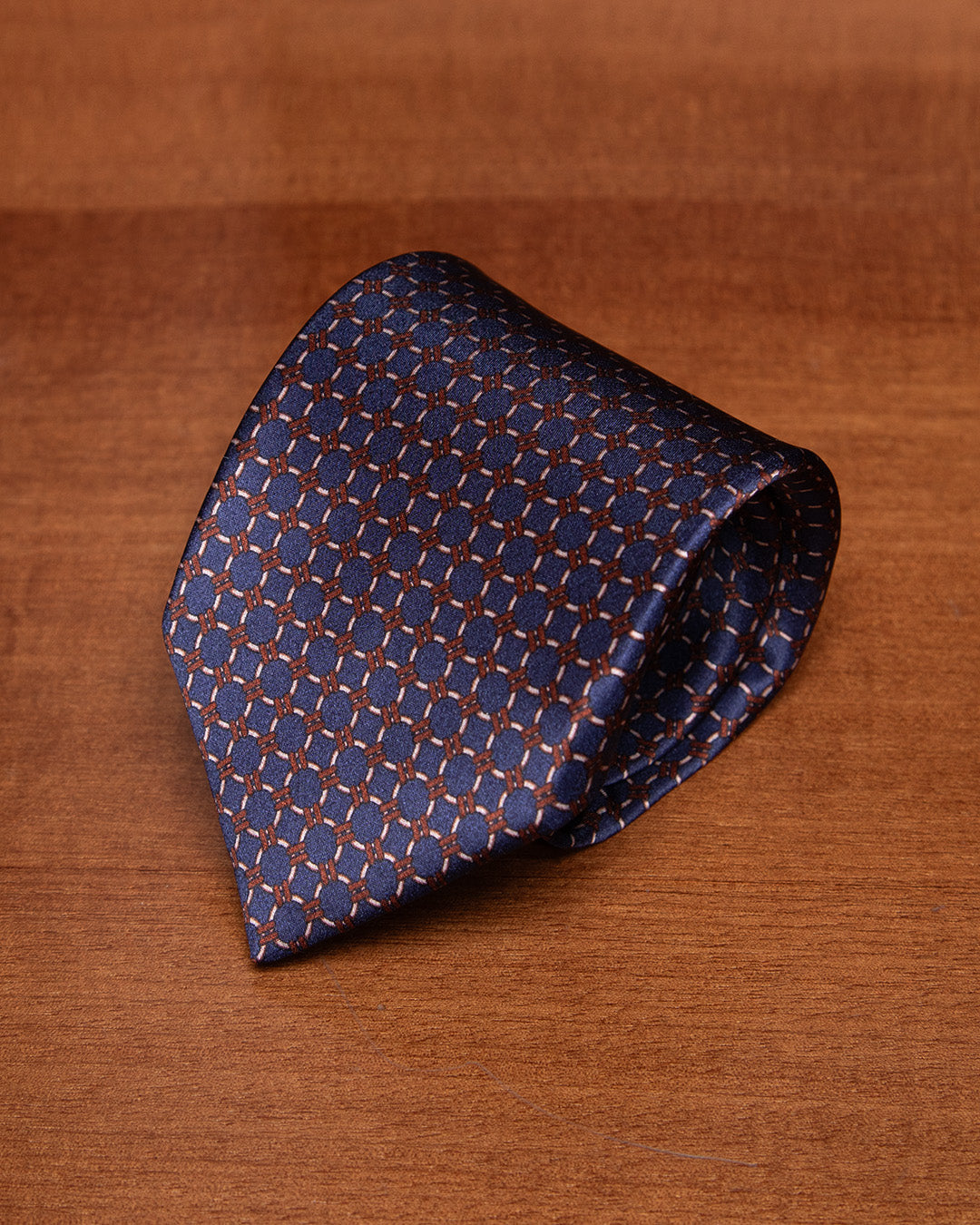 Cravatta Blu con Anelli Beige e Dettagli Bronzo