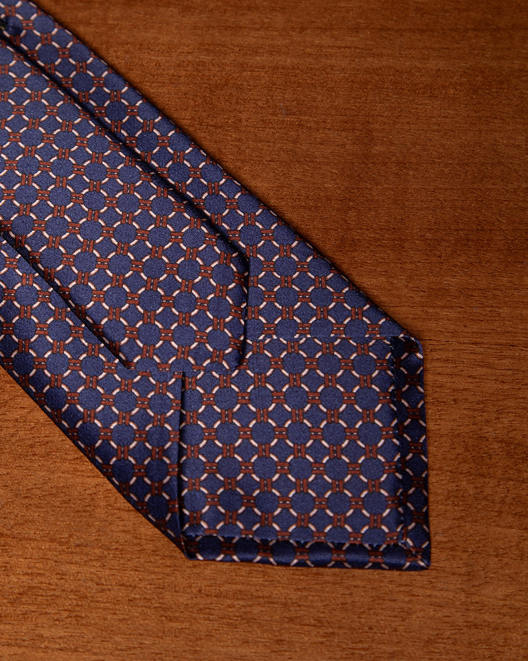 Cravatta Blu con Anelli Beige e Dettagli Bronzo