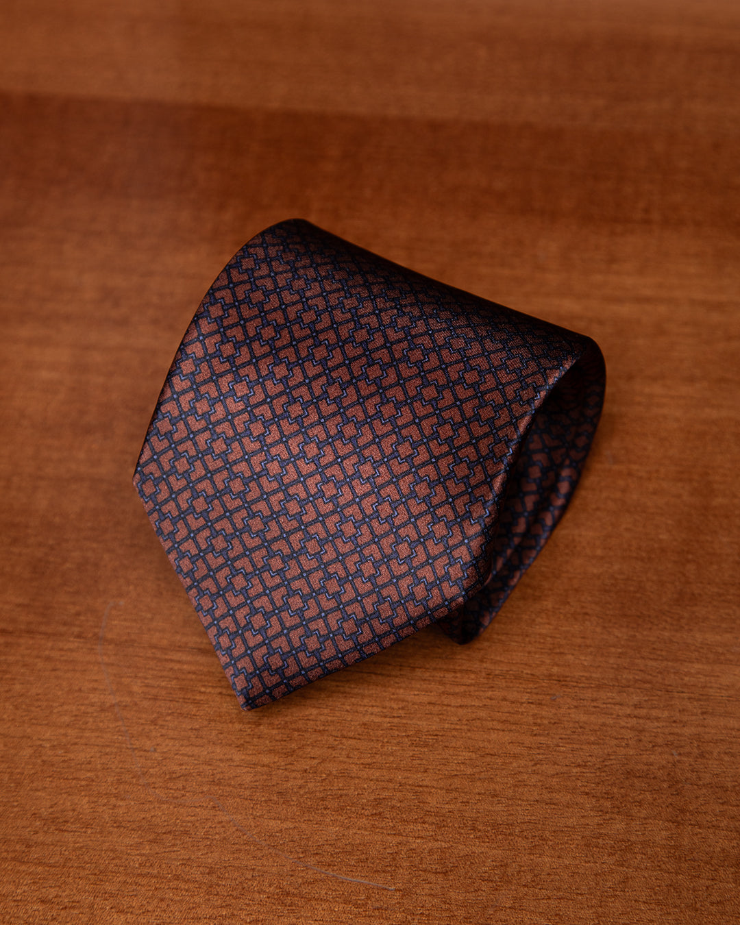 Cravatta Rame e Blu Navy con Motivo Geometrico ad Intreccio