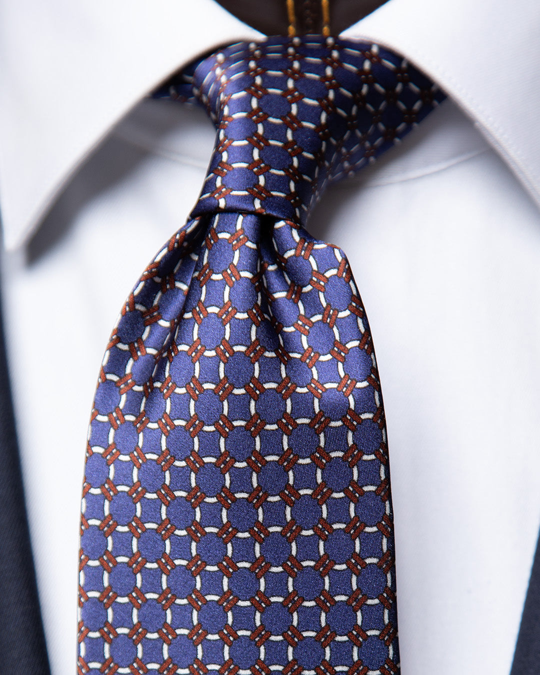 Cravatta Blu con Anelli Bianchi e Dettagli Bronzo