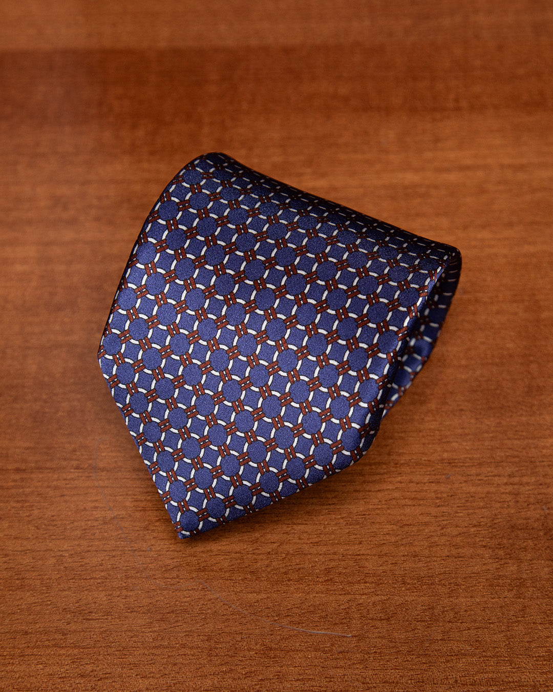 Cravatta Blu con Anelli Bianchi e Dettagli Bronzo